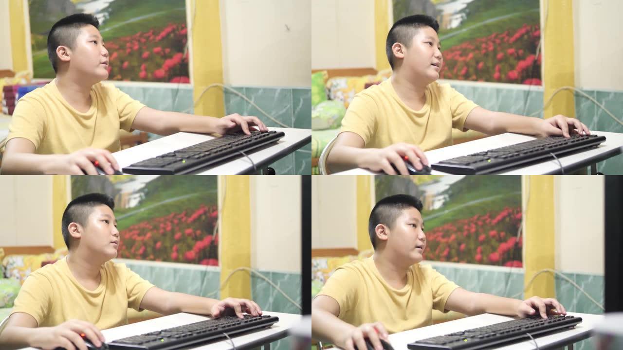 亚洲男孩在家玩电脑网络游戏，生活方式概念。