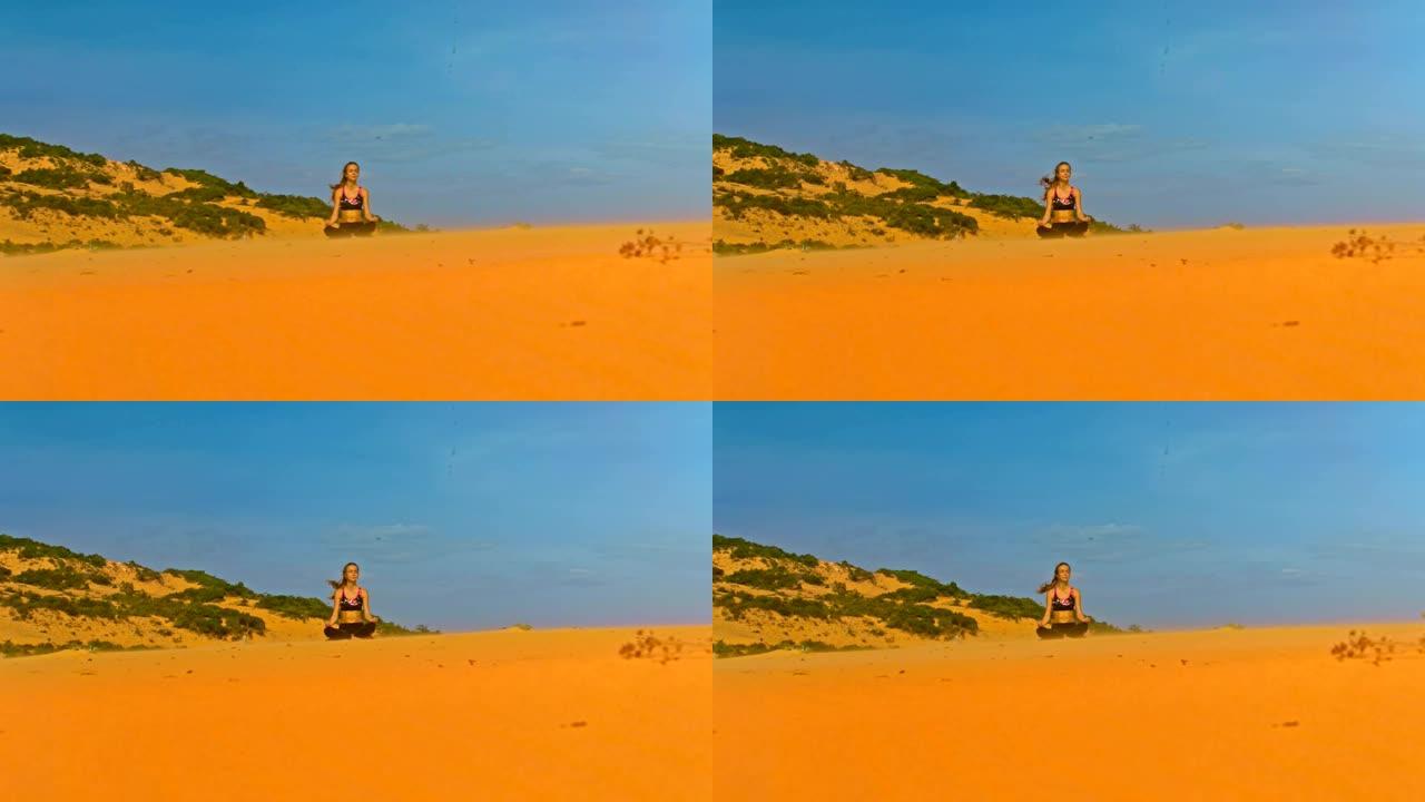 瑜伽女孩在蓝天下的金色沙丘上冥想