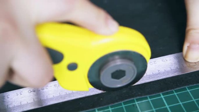 用黄色旋转切割机特写镜头切割皮革布料