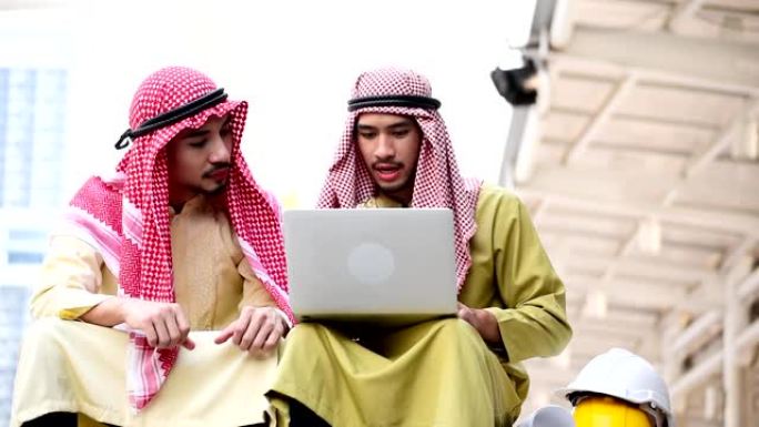 伊斯兰男子使用智能手机应用程序组织日程议程专注于手持智能手机穆斯林现代阿联酋城市。阿拉伯男子穿头巾和