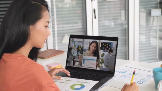 亚洲妇女在家里用笔记本电脑开会。新常态办公生活理念