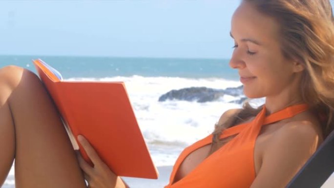 女人看着笔记本，在海洋海岸写字