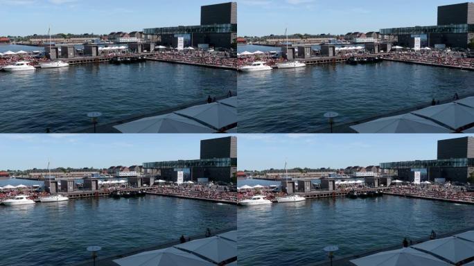 在哥本哈根的码头上观看，背景是丹麦皇家剧场。