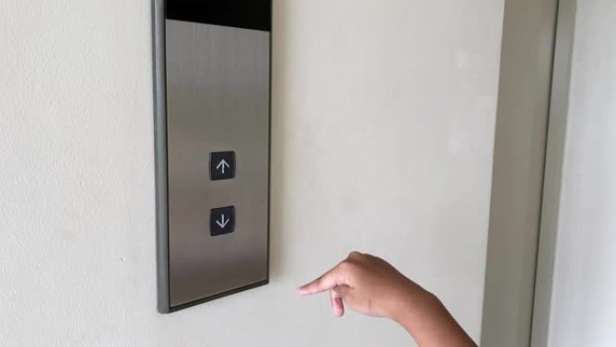 儿童手指按下电梯的向下按钮