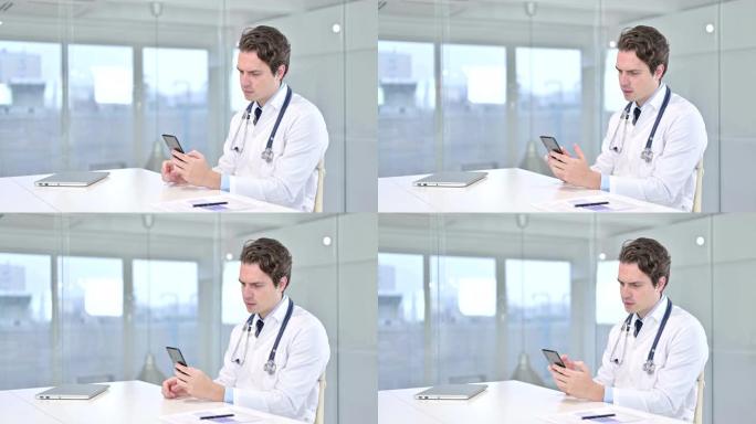 有吸引力的年轻男性医生在办公室使用智能手机