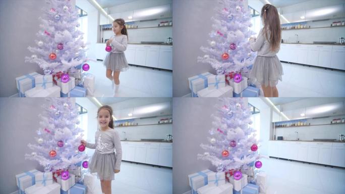 漂亮的小女孩来到最前面的圣诞树上，在其中一个树枝上放了一个玻璃摆设。