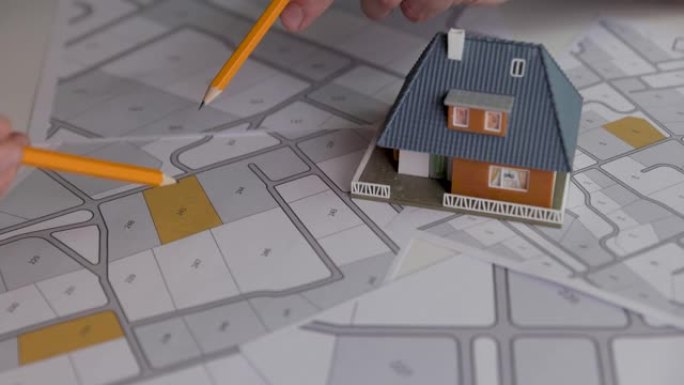 人们在地籍图上讨论和选择房屋建设的建筑图