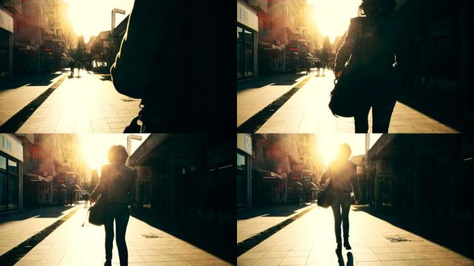 跟随一个女孩在夕阳的阳光下行走的轮廓，在欧洲城市的石头人行道上，快乐旅行的概念，在欧洲度假
