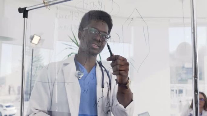 年轻的非洲医生在医院的会议室里写一些医学配方。美国黑人医生在诊所的医学会议上
