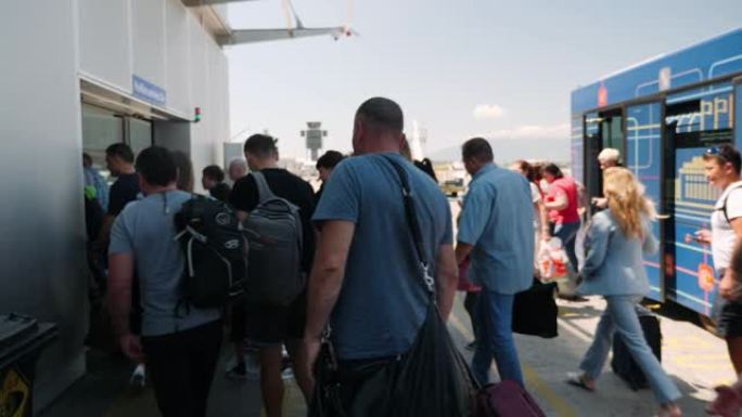 Boryspil/乌克兰-7月，19 2019-一群游客下车，前往机场。不同国籍的人从机场的客运巴士