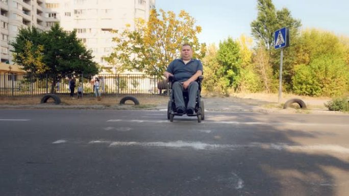 轮椅男子。残疾人。一名坐在自动轮椅上的年轻残疾人在人行横道过马路