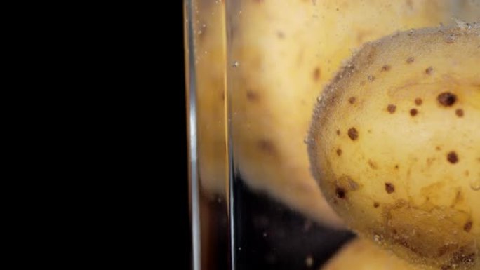 在水下有气泡的未剥皮土豆。