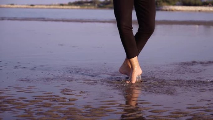赤脚男子在海边的水中展示优雅的芭蕾舞