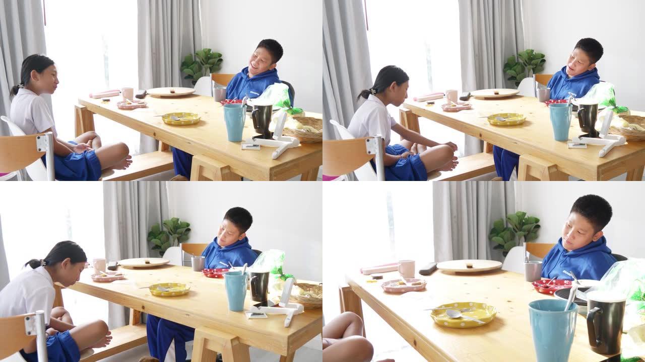 快乐的亚洲孩子早上在上学前吃早餐，狗在桌子下面。