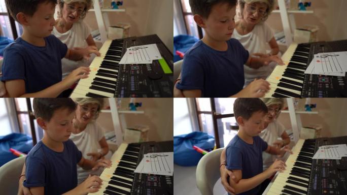 女人在康复中心的音乐治疗期间帮助小男孩玩合成器