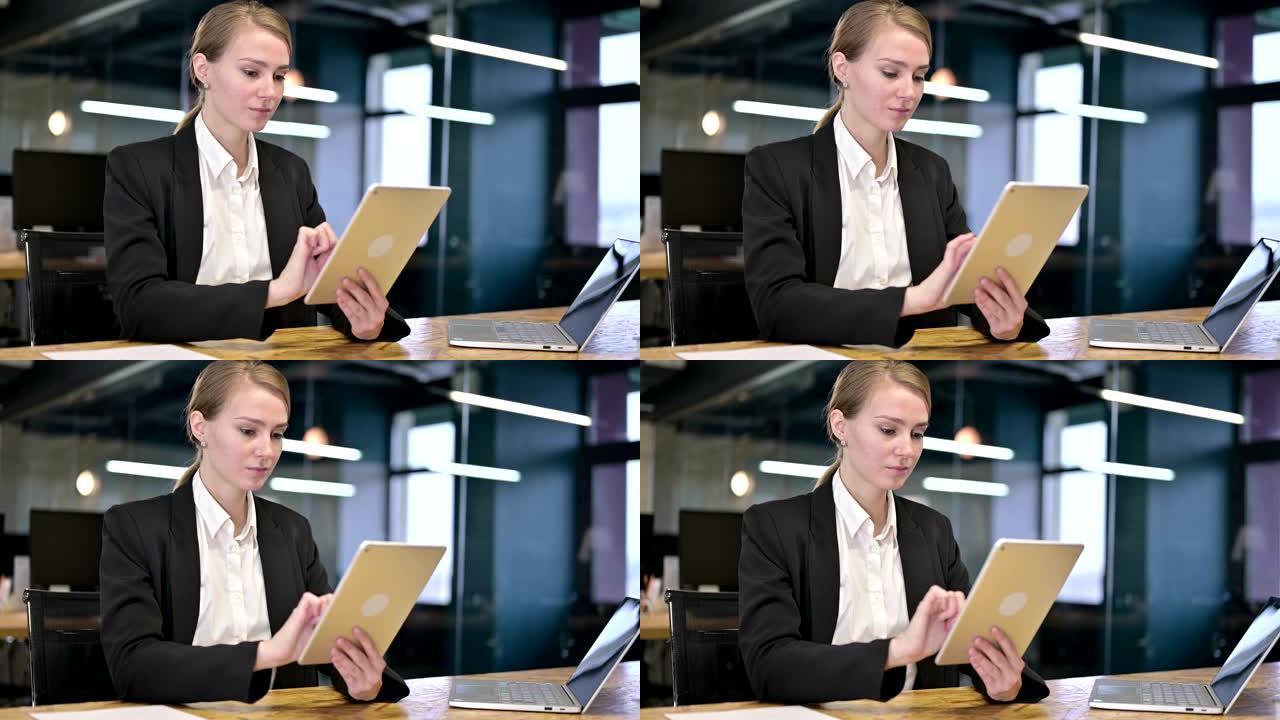在现代办公室中使用平板电脑的勤奋年轻女商人