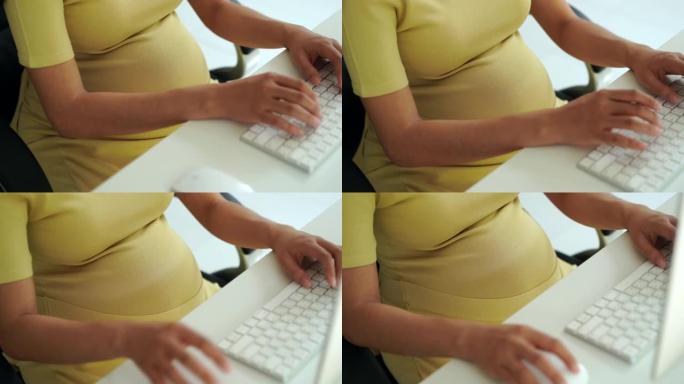 孕妇，她在办公室工作。用电脑