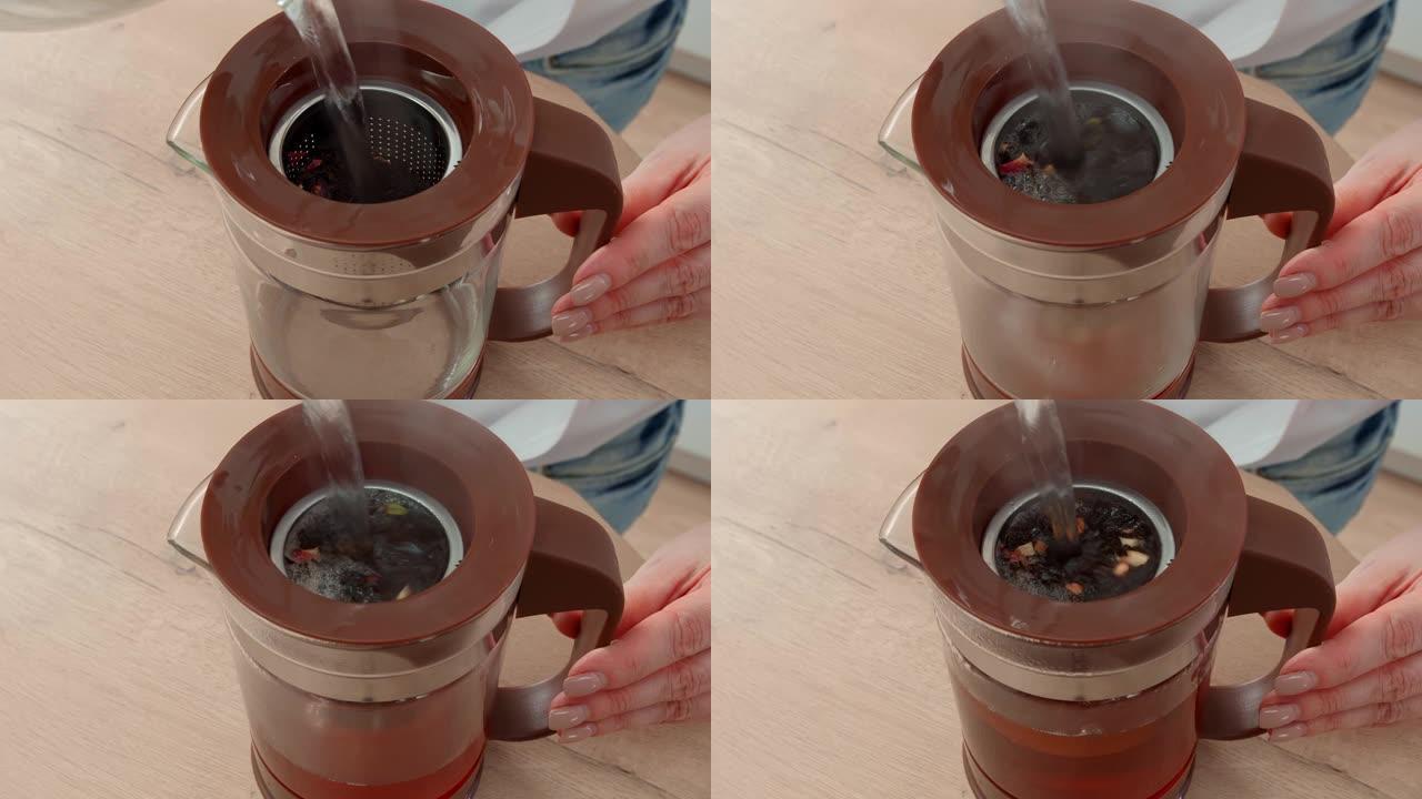一个女人早上泡红茶的特写镜头。女人将开水倒入茶壶中，在茶壶中酿造带有野生浆果的红茶