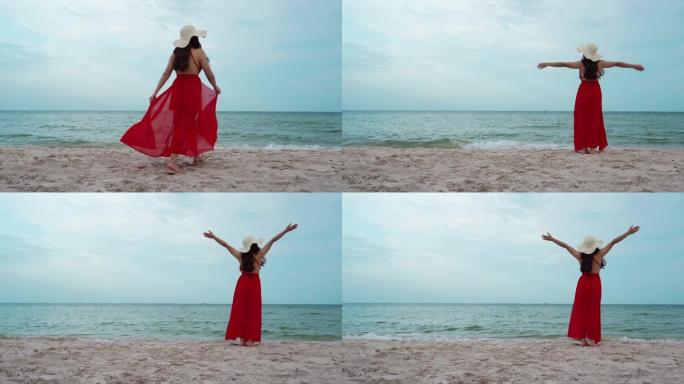 自由女人在海上海滩上举起手臂，随风而行