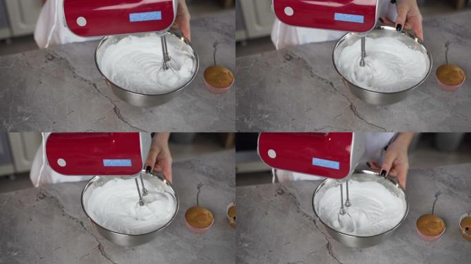 女性面包师使用电机搅拌机在碗中混合白蛋奶