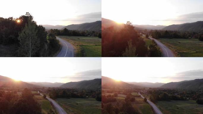 通往金色夏日日落的乡村之路-山里的日落，可以欣赏到山峦和村庄的景色-自然的舒缓场景