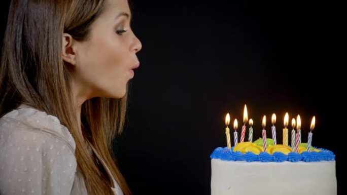 在生日蛋糕上吹灭蜡烛