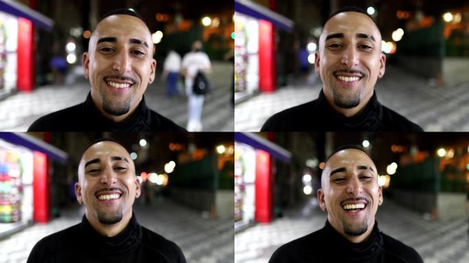 巴西西班牙裔男子晚上在城市的镜头前微笑