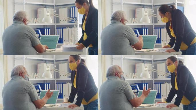在新型冠状病毒肺炎大流行期间，商人在工作中戴着防护口罩以使曲线变平。新办公室设置中的同事，共同从事项