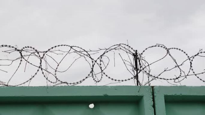 带铁丝网的监狱绿色围栏。监狱里铁丝网的特写镜头。铁丝网围栏