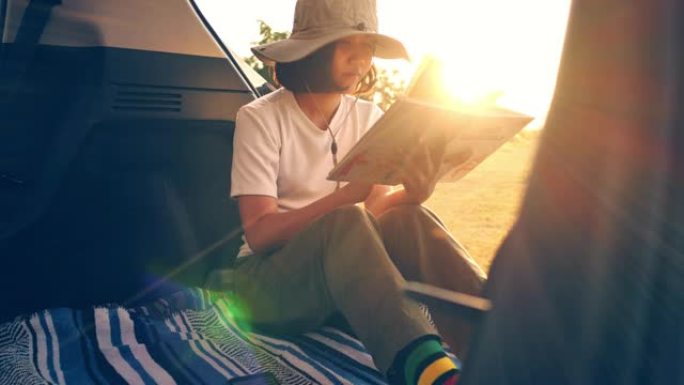 日落时在车上读书的年轻女子