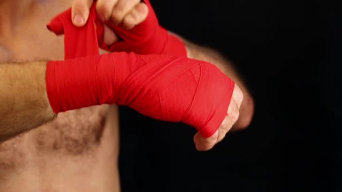 特写男子拳击手用红色包裹手腕
