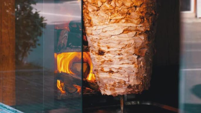 沙瓦玛 (Shawarma) 准备在人行道附近的商店橱窗上吐口水。快餐