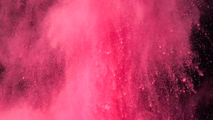 彩色红色粉末在黑暗孤立背景上的超慢动作爆炸。粉末团向上飞，与烟雾混合。