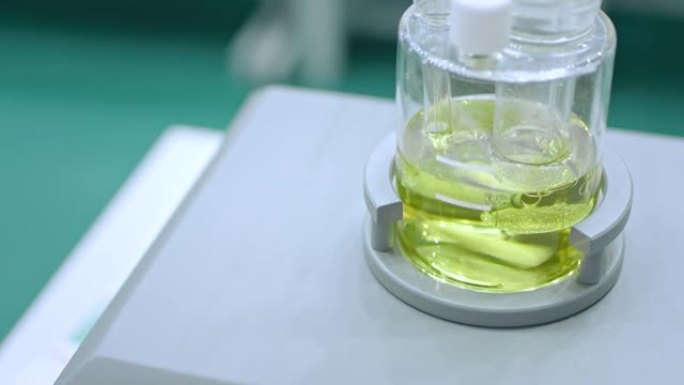 带有快速移动搅拌棒的磁性混合搅拌器，用于在药房实验室混合液体，医学展览: 特写，超慢动作。化学、科学