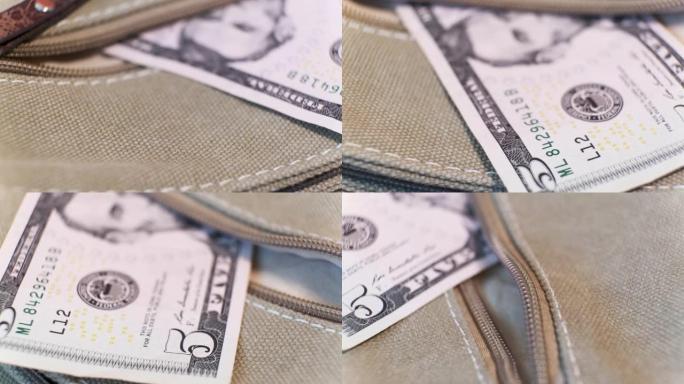 5美元钞票放在旋转桌上的帆布袋口袋里。特写，浅景深。