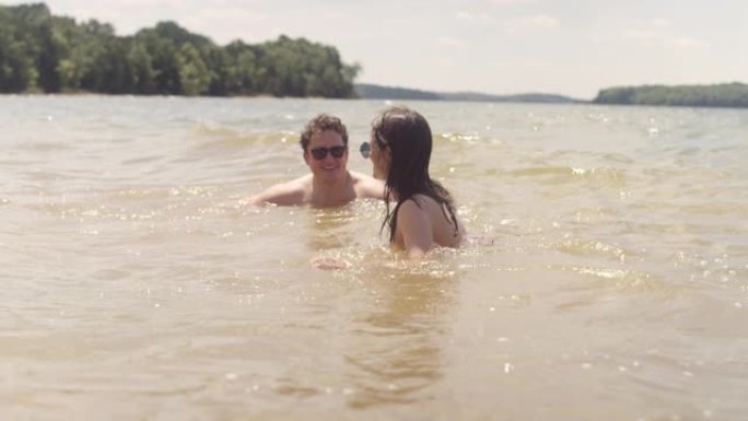 在炎热的夏日，一对夫妇在湖中玩耍