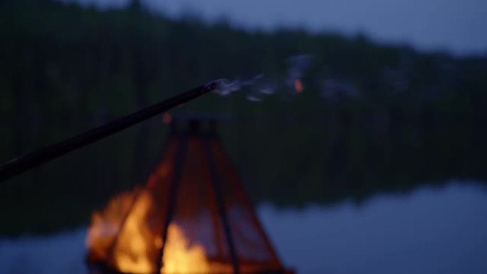 夜间湖边燃烧的木棍/篝火坑