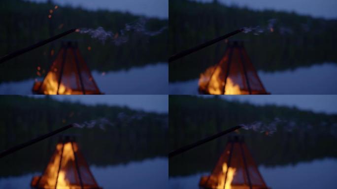 夜间湖边燃烧的木棍/篝火坑