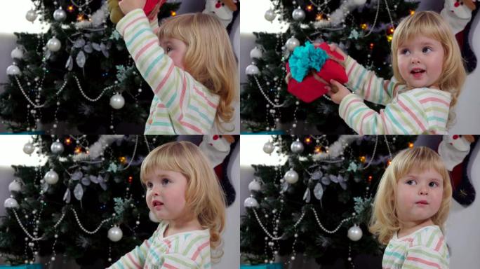 可爱的小女孩摇着圣诞礼盒