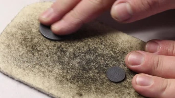 用硫磺软膏制成的铜币躺在毛毡上。一个人在毛毡上摩擦它们，逐渐露出一种解脱。