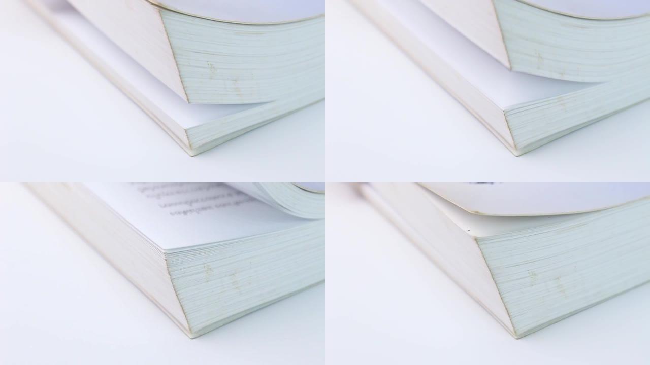 特写翻转白色桌子上一本书的页面。