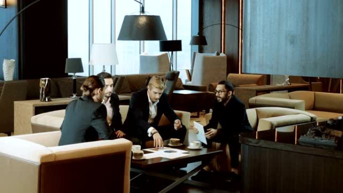 四个商人在现代餐厅的商务会议上讨论交易。4K