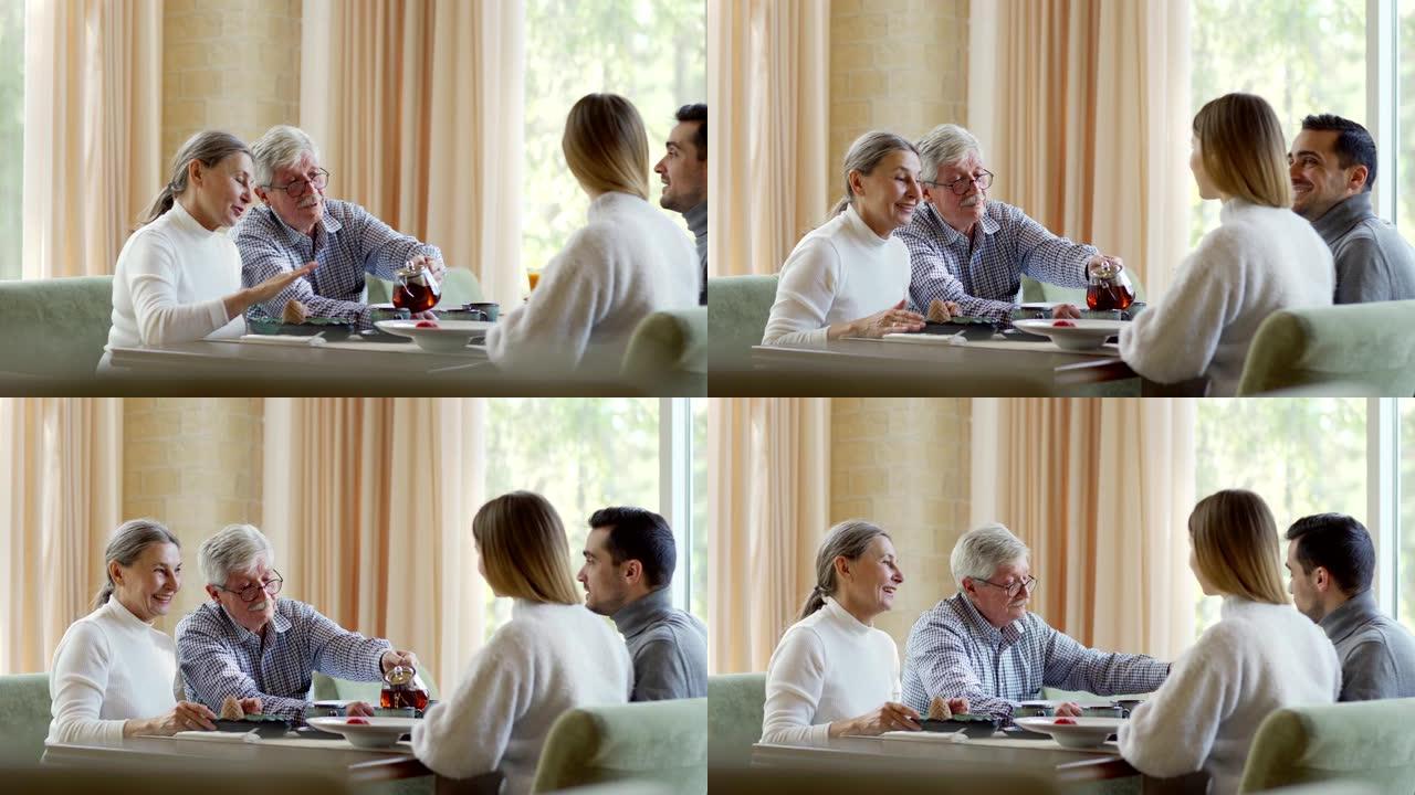 追踪年轻夫妇和老年夫妇的中等照片，两代家庭在餐厅一起吃饭。老人从锅里为妻子和儿子与女友倒茶