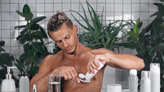 男子挤牙膏在浴室刷牙