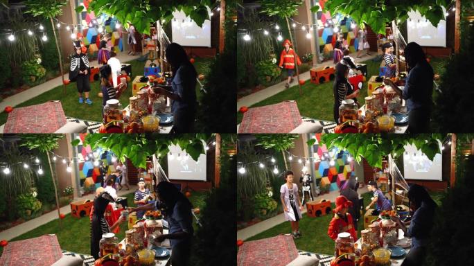 在后院电影之夜为她的孩子和他们的朋友提供糖果和爆米花