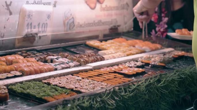 泰国街头食品小贩拿着盘子放鲑鱼寿司