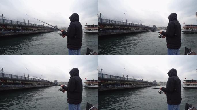 男子在雨天在加拉塔桥上钓鱼