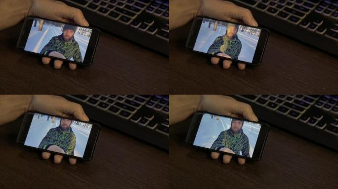 大胡子的生活方式男人在冬天的日子里与他的朋友在外面拿着智能手机进行在线视频聊天