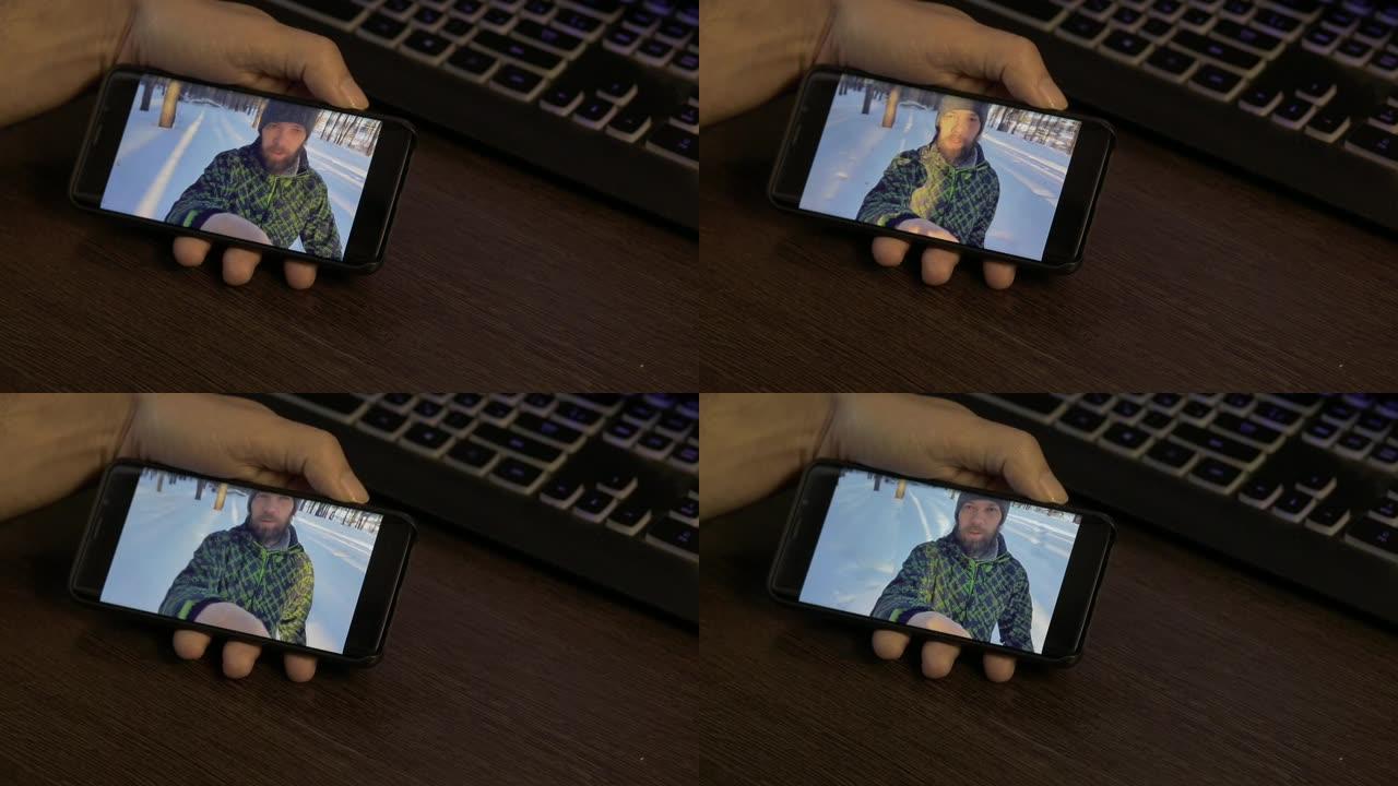 大胡子的生活方式男人在冬天的日子里与他的朋友在外面拿着智能手机进行在线视频聊天
