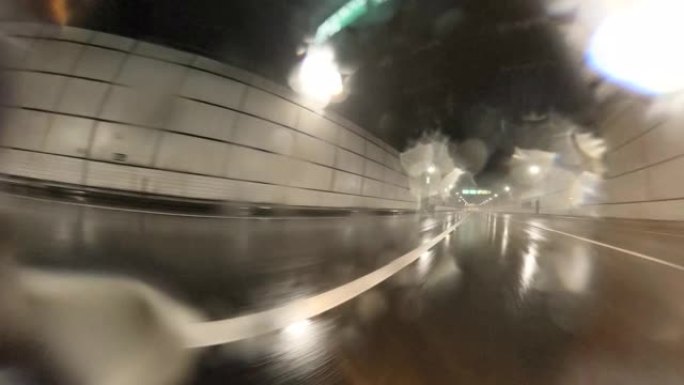 雨天开车。开车穿过隧道。镜头上的雨滴。